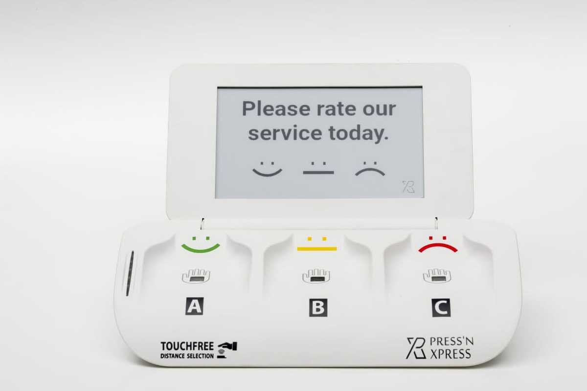 PXP TouchFree smiley terminal used as a toilet feedback machine at a washroom exit